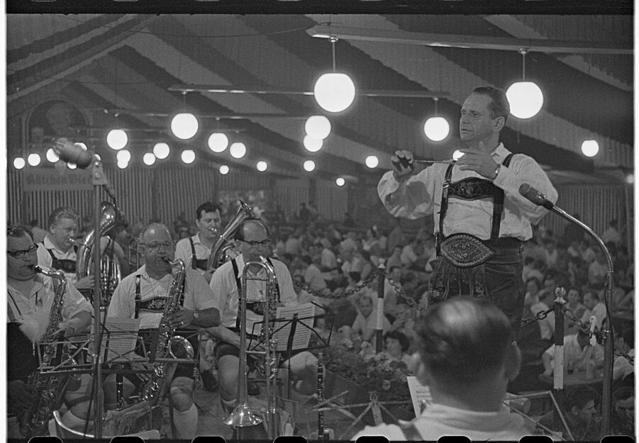 Stimmung unter dem Festzelt mit einer Trachtenkapelle im Juli 1962.