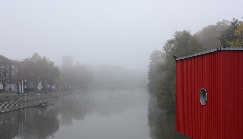 Das One Man Haus vor dem vernebelten Neckar in Heilbronn.