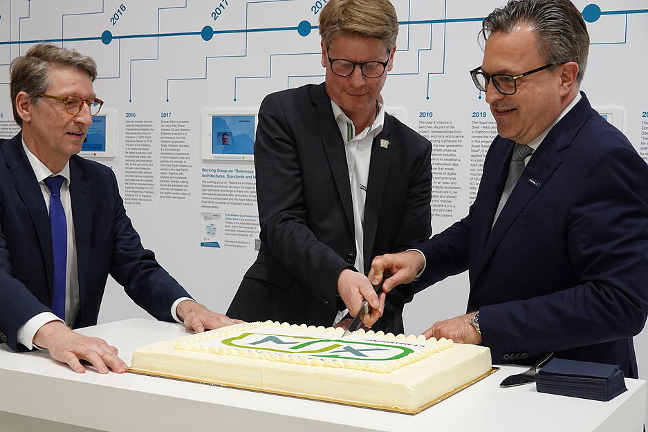 Henrik Schunk vom Lauffener Greiftechnikspezialisten Schunk &uuml;bernimmt den Lenkungskreis Industrie 4.0 und schneidet mit seinem Vorg&auml;nger in dieser Funktion, Frank Possel-D&ouml;lken (Mitte) die Torte an. Links Markus He&szlig; aus dem Bundeswirtschaftsministerium
