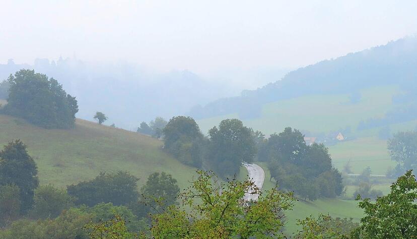 Zwischen Unterregenbach und Eberbach kann der Blick entlang des Jagsttals schweifen. Im Nebel zeichnet sich auf dem Bergkamm die Silhouette des Langenburger Schlosses ab.