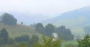 Zwischen Unterregenbach und Eberbach kann der Blick entlang des Jagsttals schweifen. Im Nebel zeichnet sich auf dem Bergkamm die Silhouette des Langenburger Schlosses ab.