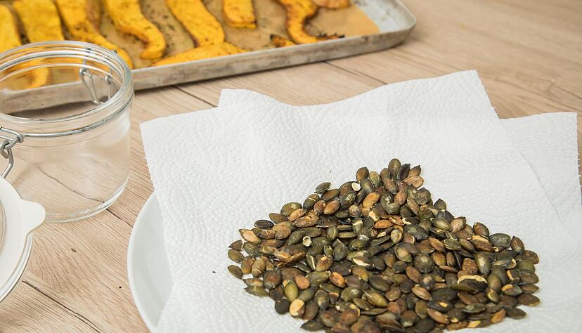 Selbstgemachte K&uuml;rbiskerne sind ein knackiges Topping f&uuml;r Salate und Suppen: Die Reste vom Halloween-K&uuml;rbis werden so sinnvoll verwertet.