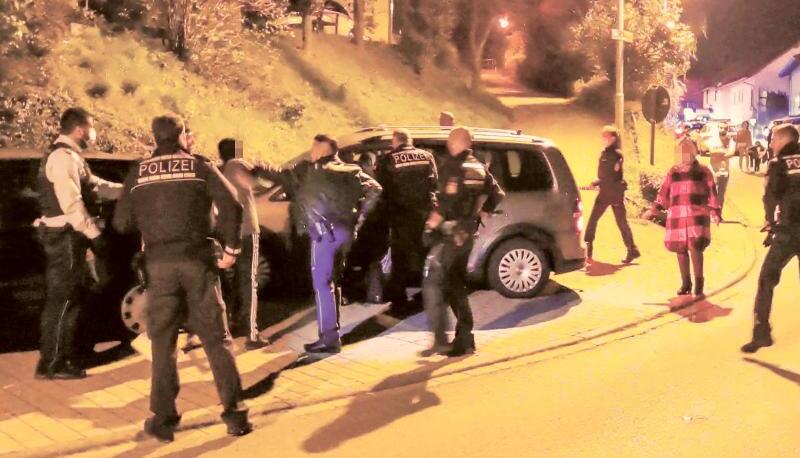 Polizisten versuchen eine Schlägerei zwischen zwei größeren Gruppen zu beruhigen.