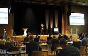 Bernd Bienzeisler vom Fraunhofer-Institut hat das Netzwerktreffen des H2Innovationslabors initiiert und morderiert durch die Veranstaltung in der Aula auf dem Bildungscampus.