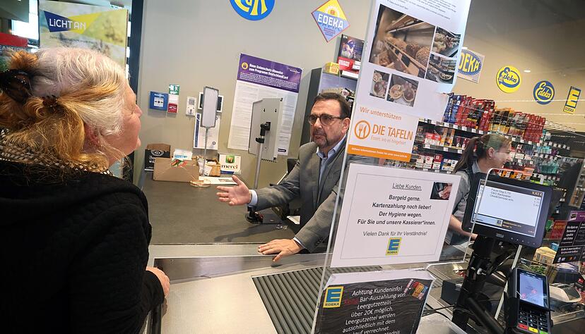 Klaus Holetschek, bayerischer Gesundheitsminister (CSU), unterh&auml;lt sich mit einer Kundin.