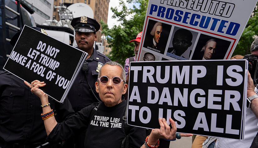 Polizeibeamte eskortieren eine Trump-Gegnerin aus dem Collect Pond Park vor dem Strafgericht in Manhattan. Polizeibeamte eskortieren eine Trump-Gegnerin aus dem Collect Pond Park vor dem Strafgericht in Manhattan.