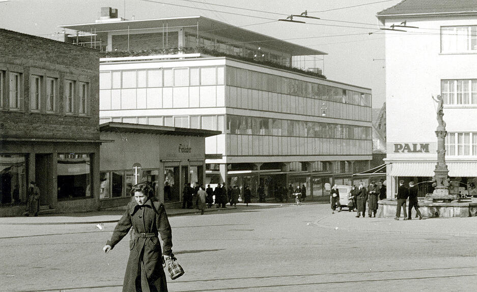 1956: Der südliche Eingang zur Fleiner Straße zeigt rechts den Fortuna-Brunnen, dahinter das Wäschegeschäft Palm. Im Zentrum ist das Warenhaus Merkur angesiedelt, links Teppich Schleicher.
