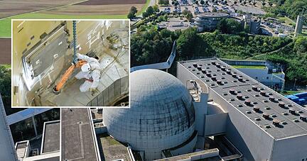 Im 2011 abgeschalteten Block I des GKN in Neckarwestheim (gro&szlig;es Foto) sind die R&uuml;ckbauarbeiten schon weit fortgeschritten. Ein Mitarbeiter bereitet ein zw&ouml;lf Tonnen schweres Betonsegment aus dem Ringtr&auml;ger, in dem der Reaktorbeh&auml;lter verankert war, f&uuml;r den Abtransport per Kran vor (kleines Foto).