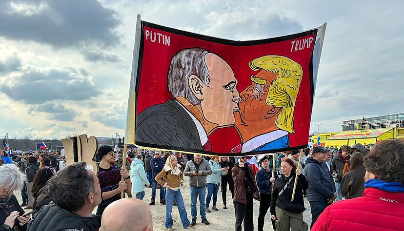 Demonstranten halten bei einer Kundgebung des B&uuml;ndnisses &laquo;Eine Million Augenblicke f&uuml;r Demokratie&raquo; ein Banner, auf dem sich stilisiert US-Pr&auml;sident Trump und Russlands Pr&auml;sident Putin k&uuml;ssen.