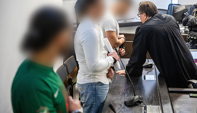 Drei Angeklagte stehen bei Prozessbeginn mit Handschellen im Landgericht Stuttgart. Drei Angeklagte stehen bei Prozessbeginn mit Handschellen im Landgericht Stuttgart.