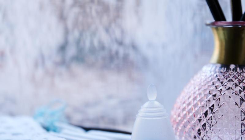 Eine Menstruationstasse, Slipeinlagen und Tampons verschiedener Hersteller liegen in einem Badezimmer.