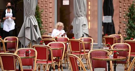 Viele freie Tische vor einem Caf&eacute; in Frankfurt.