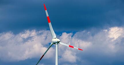 Eine Windkraftanlage dreht sich in einem Windpark.
