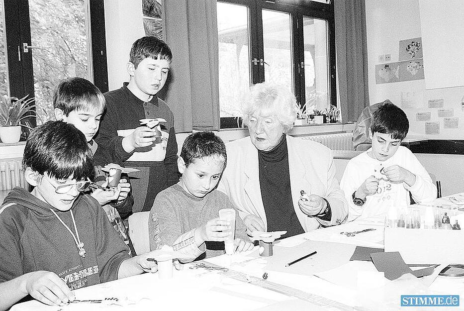 1999: Die Meseno-Kinderstunde trifft sich in den R&auml;umen der Heilbronner  Dammgrundschule. Jutta M&uuml;ller, ehrenamtliche Mitarbeiterin, bastelt Kerzenst&auml;nder und &uuml;bt ganz nebenbei mit den Sch&uuml;lern das genaue Ausschneiden mit der Schere.