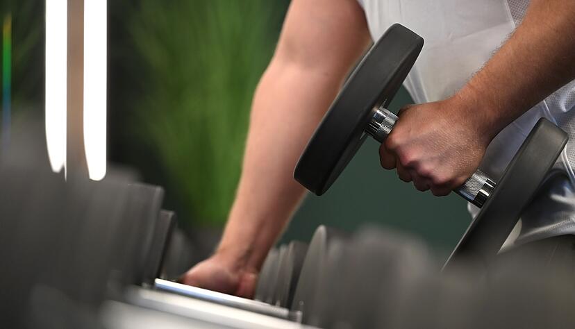 Ran an die Hanteln: ein Mann beim Training in einem Fitnessstudio.