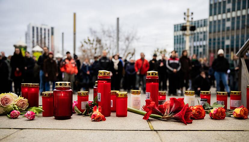 Menschen zünden Kerzen an und legen Blumen nieder. Menschen zünden Kerzen an und legen Blumen nieder.