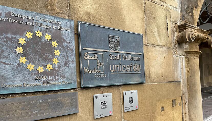 Gleich ein doppelter Aufschlag: Am Rathaus, unterhalb der Treppe zum Haupteingang, gibt es zwei QR-Codes, die man abscannen kann.