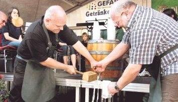Zunächst saß die Gummidichtung falsch. Doch dann - nach etlichen Fehlversuchen von Bürgermeister Norbert Heuser (links) - floss das Bier in die Krüge.Foto: Plückthun