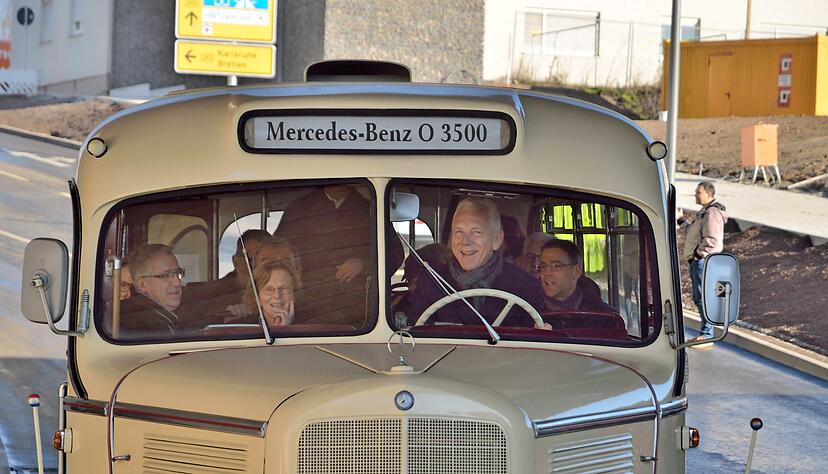 OB Harry Mergel übernimmt kurzzeitig das Steuer des historischen Busses, der als erster durch die Unterführung fahren darf. Mit dabei sind zahlreiche Stadträte.