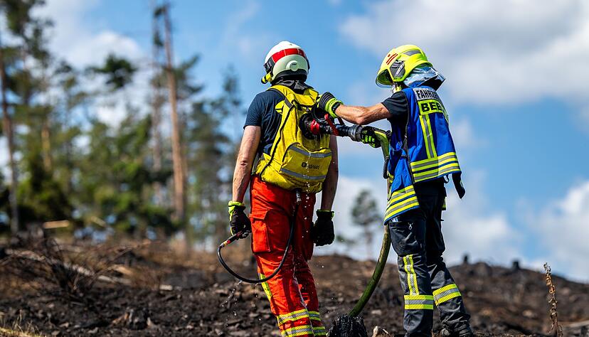 Mit L&ouml;schrucks&auml;cken gehen die Feuerwehrleute etwa gegen Glutnester vor.