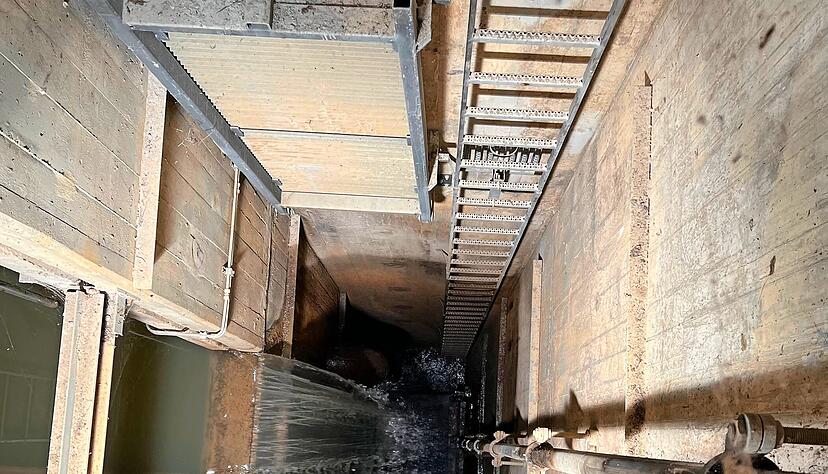 Robert Böhnel steigt hinab: Wer nicht nur hören, sondern auch sehen will, wie das Wasser vom Staubecken weiterfließt, muss im engen Technikgebäude die Leiter hinunterklettern. 
 Fotos: Beate Windisch