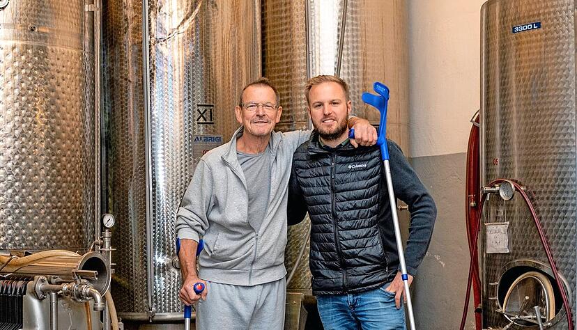 Werner K&uuml;hner (links) arbeitet sich nach der OP mit Kr&uuml;cken in den Alltag zur&uuml;ck. Er ist heilfroh, dass sein guter Nachbar Alexander Bauer einige Kollegen f&uuml;r die Ernte seiner reifen Trauben gewinnen konnte.