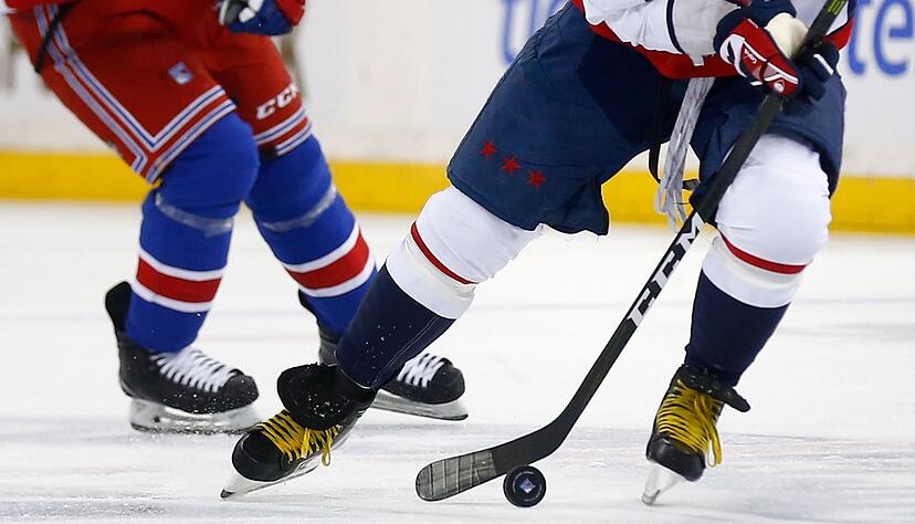 Zwei Eishockeyspieler k&auml;mpfen um den Puck.