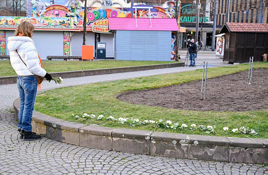 Eine Frau legt in der Nähe des Mannheimer Paradeplatzes weiße Rosen auf eine Grünfläche. Am Vortag war hier ein Auto in eine Menschenmenge gefahren. Zwei Personen wurden tödlich und mehrere schwer verletzt. Eine Frau legt in der Nähe des Mannheimer Paradeplatzes weiße Rosen auf eine Grünfläche. Am Vortag war hier ein Auto in eine Menschenmenge gefahren. Zwei Personen wurden tödlich und mehrere schwer verletzt.