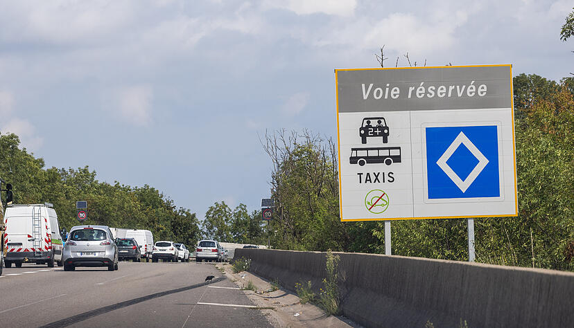 Ein Schild mit der Aufschrift "Voie r&eacute;serv&eacute;e" weist neben einer Autobahnauffahrt auf eine Spur f&uuml;r Fahrgemeinschaften, Taxis und Busse hin.