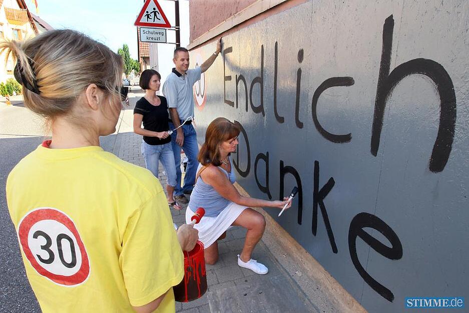 21.07.2010: Ihr Dank f&auml;llt deutlich aus: Mitglieder der B&uuml;rgerinitiative feiern auf der Front eines leer stehenden Hauses den Erfolg ihrer Bem&uuml;hungen.