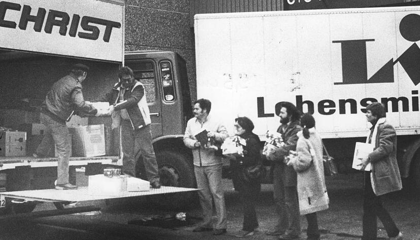 Zusammengestellt von Archiv und Dokumentation der Heilbronner Stimme 
Bilder vom Transport der Heilbronner Hilfssendung "Menschen in Not" (MIN) der Heilbronner Stimme nach Oberschlesien, fotografiert vom HSt-Redaktionsmitglied Hans Georg Frank 
Dezember 1981: Auf Fahrzeuge der Firmen Spedition Christ, Heilbronn und Lidl & Schwarz, Neckarsulm verl&auml;dt die Begleitmannschaft des Hilfs-Konvois nach Polen Lebensmittel und G&uuml;ter des t&auml;glichen Bedarfs. Im Bild ist die Heilbronnern Delegation von links: Rolf Barth, Siegfried Zimmermann, Helmut Fischer, Maria Maurer, Hans Georg Frank, Luise Sigrid Gerstenberg und Nikolaus Pflanzer vor der Abfahrt nach Kattowitz. Ob die Lastwagen tats&auml;chlich fahren k&ouml;nnen, h&auml;ngt von der weiteren Entwicklung der politischen Lage in Polen ab.