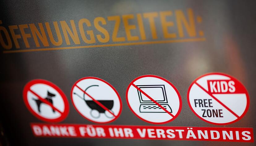 An einer Scheibe der Caf&eacute;-Bar 8tto Grammi weist ein Schild auf das Verbot von Laptops hin - wie auch auf das Verbot f&uuml;r Hunde, Kinderw&auml;gen und auf eine kinderfreie Zone.