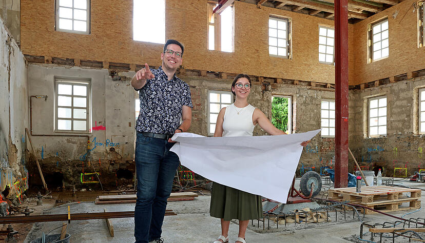 B&uuml;rgermeister Felix Pontow und Bauamtsleiterin Lena St&uuml;rzl mit  Baupl&auml;nen in der Ellhofener Rathausbaustelle. Bis 2026 dauert die Sanierung und Erweiterung.