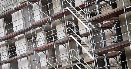 Ein Gerüst steht an einem Neubau für Wohnungen. Der Wohnungsneubau in Deutschland kommt zunehmend unter Druck.