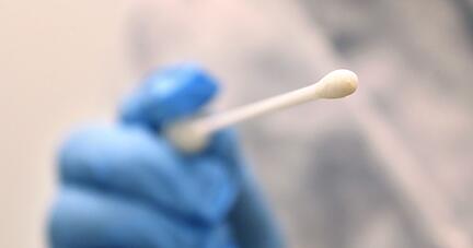 Ein Arzt hält einen Tupfer, mit dem ein Abstrich für einen Coronatest gemacht wird. Ein Arzt hält einen Tupfer, mit dem ein Abstrich für einen Coronatest gemacht wird.