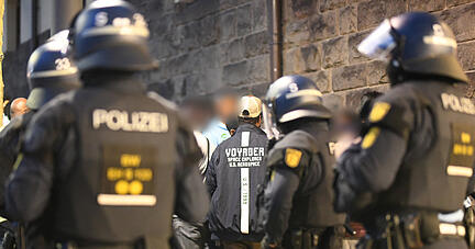 Eine Gruppe von Menschen wird nach Ausschreitungen bei einer Eritrea-Veranstaltung von Polizeikräften eingekesselt.