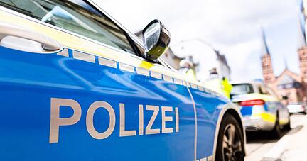 Zwei Streifenwagen der Polizei stehen am Stra&szlig;enrand.