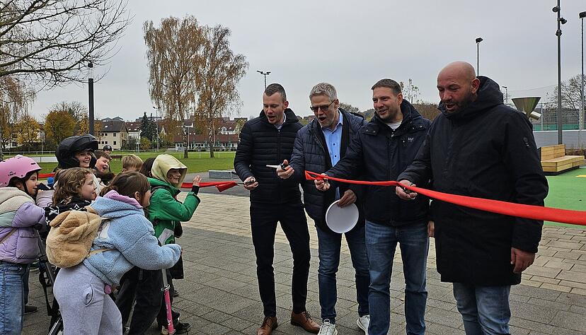 Eins, zwei, drei: Bürgermeister Steffen Braun, Michael Link (von links) und weitere am Bau Beteiligte durchtrennen das rote Band zur offiziellen Einweihung – sehr zur Freude der Kinder.