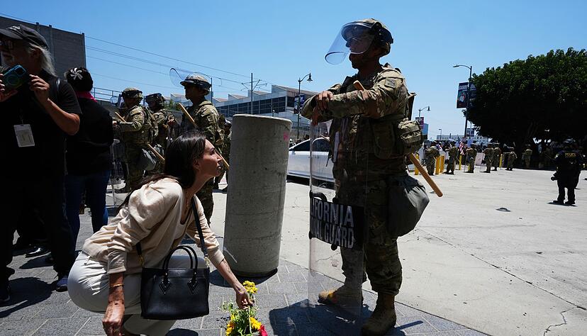 Eine Frau legt Blumen vor der Nationalgarde nieder.