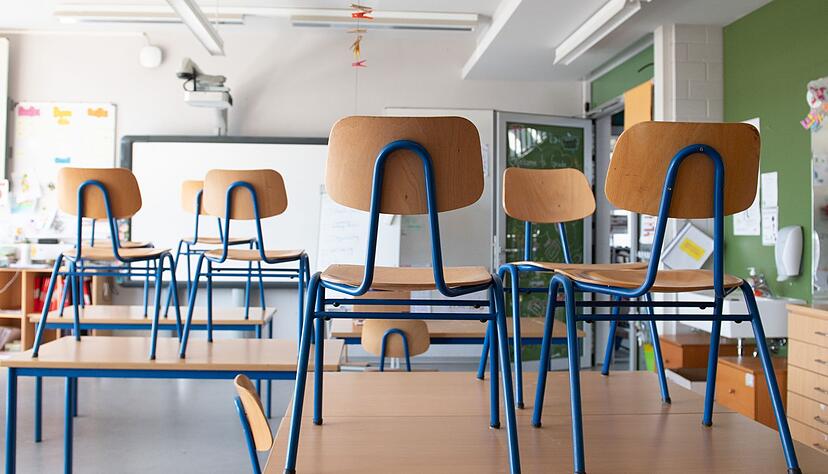 Stühle stehen in einem Klassenzimmer auf den Tischen. Stühle stehen in einem Klassenzimmer auf den Tischen.