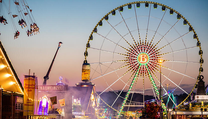 Nach Sonnenuntergang laufen zahlreiche Menschen über den Cannstatter Wasen und besuchen das 84. Stuttgarter Frühlingsfest. Nach Sonnenuntergang laufen zahlreiche Menschen über den Cannstatter Wasen und besuchen das 84. Stuttgarter Frühlingsfest.