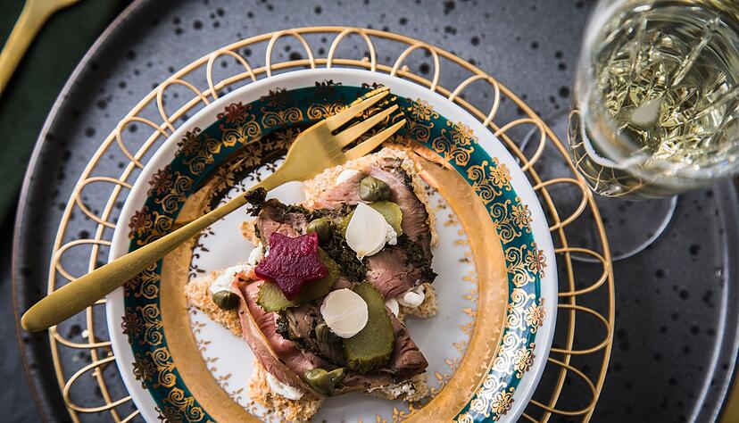 Deftiger Start in den Abend: eine Toastscheibe mit Roastbeef, Roter Bete, Kapern, Cornichons, Silberzwiebeln und Meerrettich.