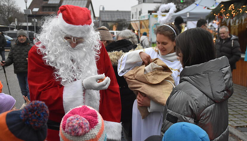 In Scharen umringen die Kinder den Nikolaus, der zwischen den St&auml;nden hinter dem Rathaus wandelt. F&uuml;r jeden hat er einen Apfel, Gummib&auml;rchen oder Schokolade dabei.