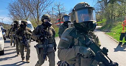 Ein Mitglied eines Spezialeinsatzkommandos (SEK) wird angeschossen. Mehr als 200 Beamte sind am Mittwoch vor Ort. Als der Gebäudekomplex abgebrannt ist, durchsucht das SEK das Haus. Immer wieder sind Explosionen zu hören.
Fotos: Jürgen Kümmerle