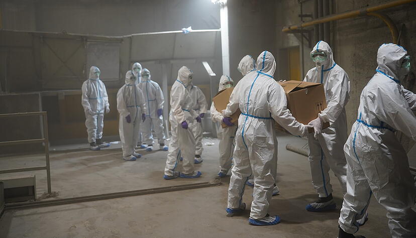 Polizisten in Schutzanzügen verladen sichergestelltes Kokain.