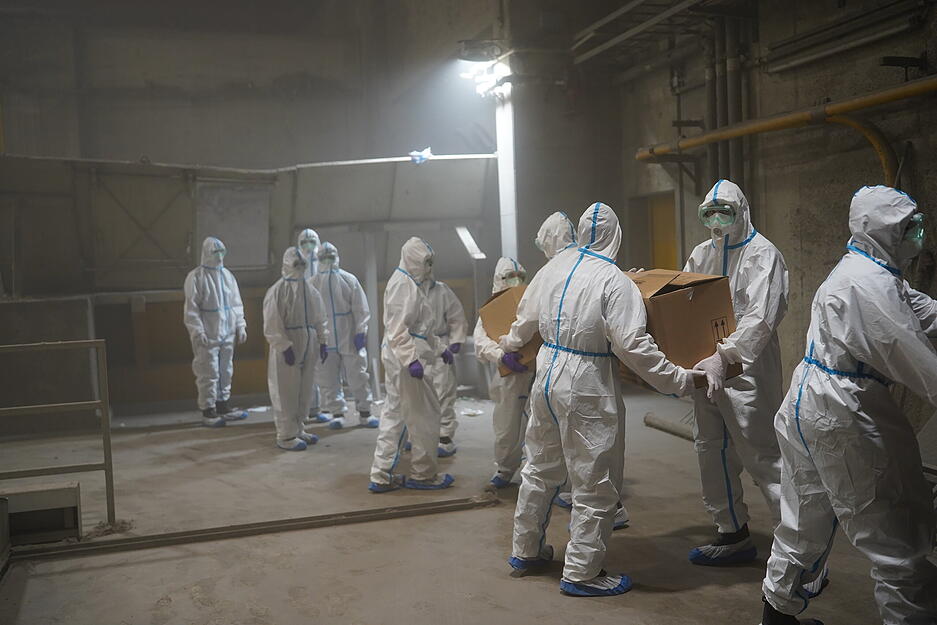 Polizisten in Schutzanzügen verladen sichergestelltes Kokain. Polizisten in Schutzanzügen verladen sichergestelltes Kokain.