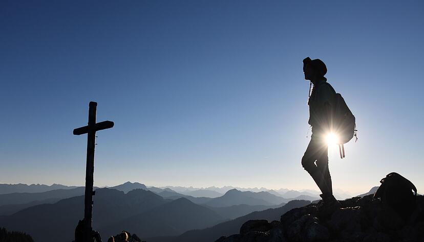 Eine Ausflüglerin genießt den Blick am Gipfelkreuz des Taubensteins. Eine Ausflüglerin genießt den Blick am Gipfelkreuz des Taubensteins.