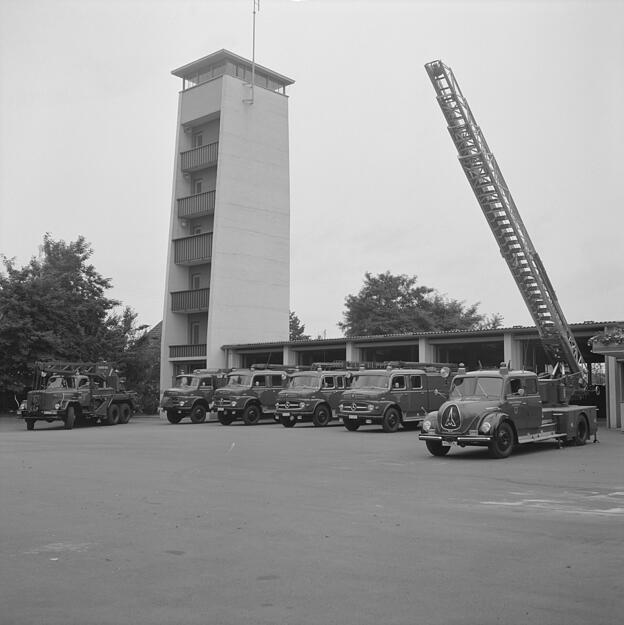1966: Blick auf die Fahrzeuge vor der Fahrzeughalle. Links ist der Schlauchturm zu sehen.