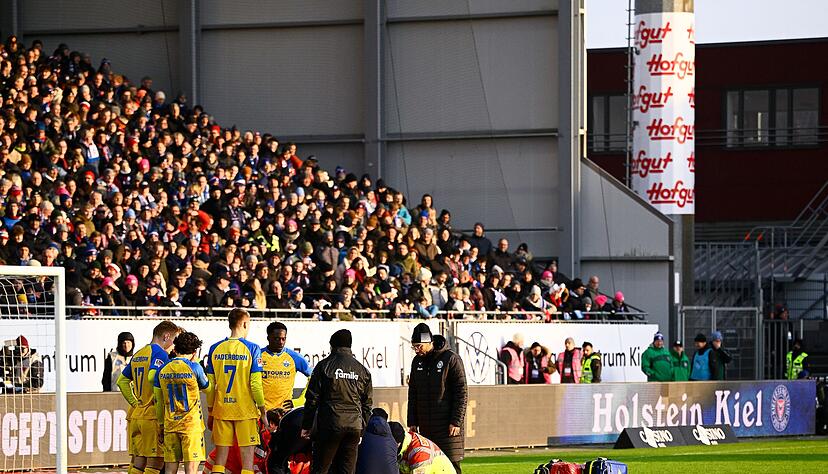 Paderborns Spieler Calvin Brackelmann wird auf dem Rasen von Sanit&auml;tern behandelt.