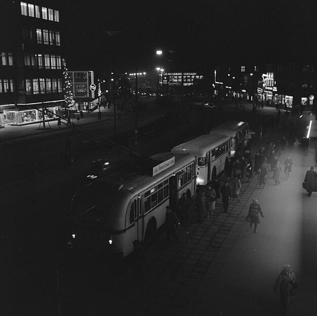 Dezember 1959: Die Nachtaufnahme zeigt die Heilbronner Allee und das beleuchtete Modehaus Barthel, links im Bild. Im Vordergrund ist die OBus-Haltestelle an der Post.
